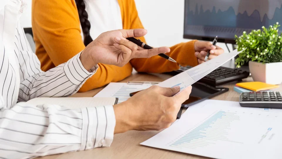 Two people review an employee compensation package together.